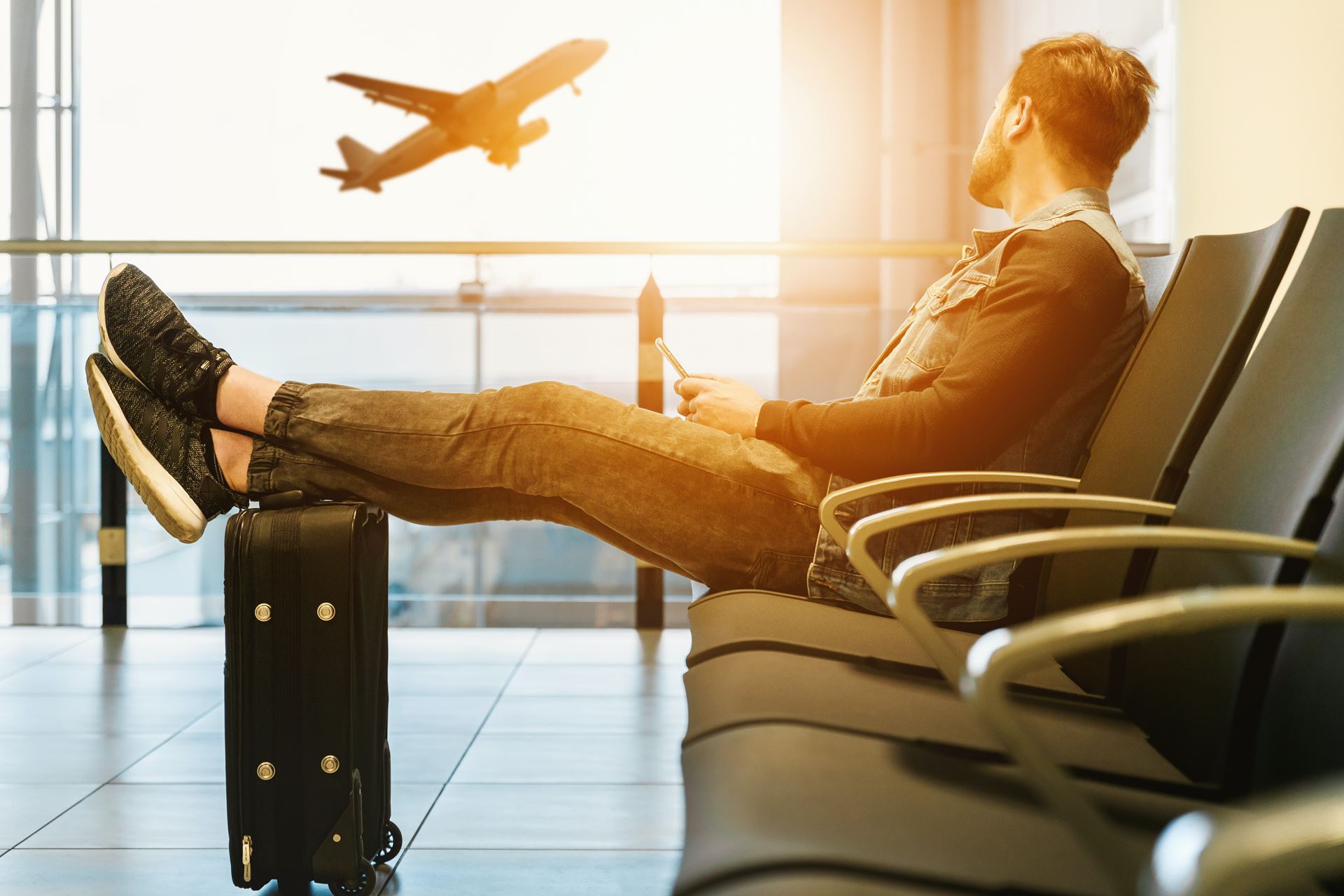 a man in the waiting area of an airport departure gate