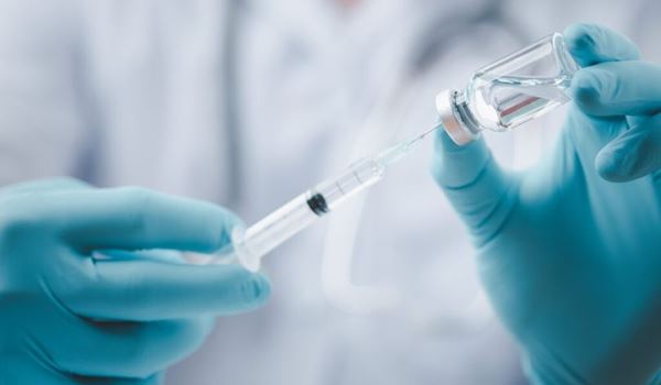 A clinician drawing up a vaccine from a vial