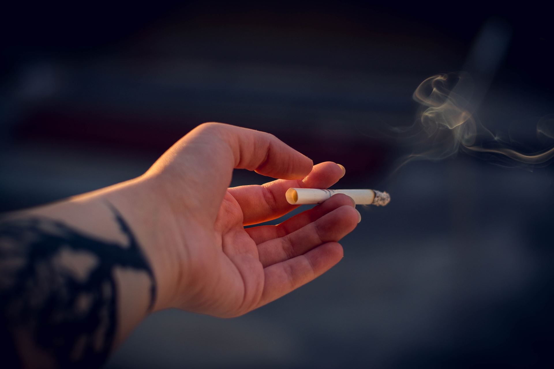 a close up of a hand holding a cigarette